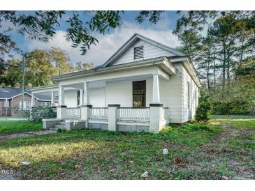 Charming home with inviting front porch and classic architectural details in a suburban landscape at 703 Cokey Rd, Rocky Mount, NC 27801
