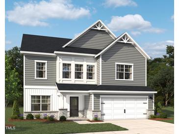 Charming two-story home featuring gray siding, a two-car garage, and a well-manicured lawn in a suburban setting at 709 Compeer Way # 32, Rolesville, NC 27571