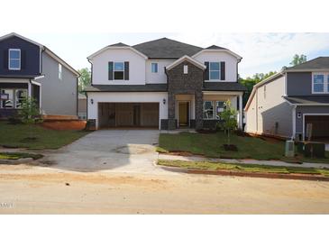 Two-story home featuring a spacious two-car garage, brick accents, and newly installed grass at 709 Deschutes Dr, Garner, NC 27529