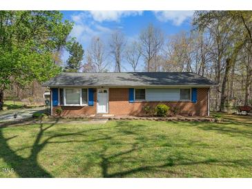 Charming brick home with well-maintained lawn and mature trees offering great curb appeal at 711 Melanie St, Durham, NC 27704