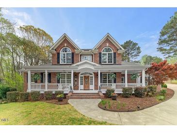 Beautiful two-story brick home with a welcoming front porch and manicured landscaping at 7336 Barham Hollow Dr, Wake Forest, NC 27587