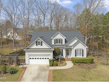 Charming home featuring a two-car garage, manicured lawn, and mature trees at 8308 Buck Crossing Dr, Durham, NC 27713