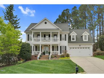 Inviting two-story traditional-style home boasting a charming double porch and well-manicured front lawn at 1113 Colonial Club Road Rd, Wake Forest, NC 27587