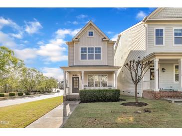 Charming two-story home with a cozy front porch and manicured lawn at 115 Windy Creek Ln, Apex, NC 27502