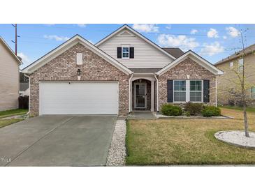 Charming one-story brick home with an attached garage, manicured lawn, and classic architectural details at 1728 Fern Hollow Trl, Wake Forest, NC 27587