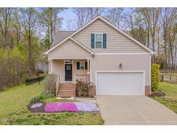 Charming home featuring a well-manicured lawn and an attached two-car garage and beautiful landscaping at 190 Alcock Ln, Youngsville, NC 27596