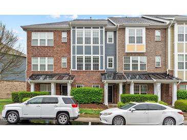 Charming townhomes with brick facade, multiple windows, and manicured landscaping at 228 Dove Cottage Ln, Cary, NC 27519
