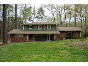 Charming home with a combination of brick and green siding and a well-manicured lawn at 3518 Donnigale Ave, Durham, NC 27705