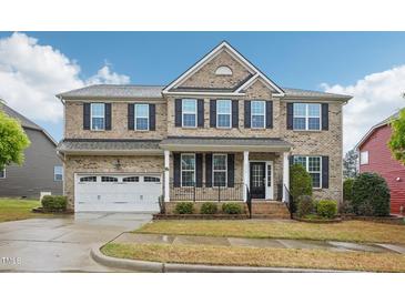 Beautiful two-story brick home with manicured lawn, attached garage, and inviting front porch at 4008 Sykes St, Cary, NC 27519