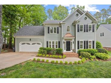 Charming two-story home with a well-manicured lawn and a two-car garage at 5109 Windance Pl, Holly Springs, NC 27540