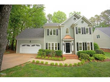 Charming two-story home with a manicured lawn and a two-car garage at 5109 Windance Pl, Holly Springs, NC 27540