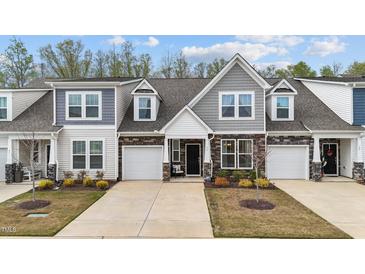 Charming townhome featuring a stone facade, gray shingle accents, and well-maintained landscaping at 53 Whitley Ridge Dr, Clayton, NC 27527