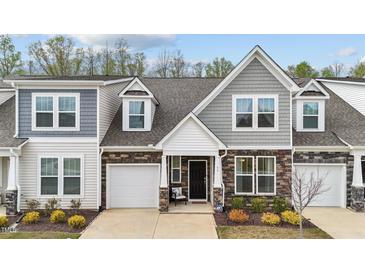 Charming two-story townhome with a stone and siding exterior, complemented by a well-manicured lawn at 53 Whitley Ridge Dr, Clayton, NC 27527