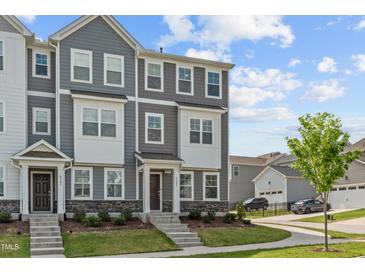 Charming townhome with gray siding, white trim, stone accents, and a well-manicured lawn at 6309 Truxton Ln, Raleigh, NC 27616
