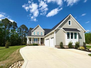 Beautiful craftsman style home with a manicured lawn and attached three-car garage at 6521 Camellia Creek Dr, Raleigh, NC 27603