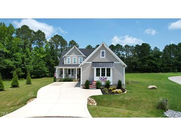 Beautiful two-story home featuring gray siding, black roof, and manicured front lawn at 6521 Camellia Creek Dr, Raleigh, NC 27603