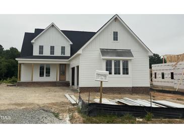 New construction two-story home with white siding, a black roof, and an attached garage under cloudy skies at 1029 Azalea Garden Cir, Raleigh, NC 27603