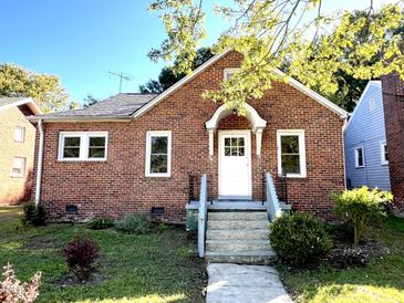Charming brick home featuring a classic design, well-maintained lawn, and welcoming front entrance at 111 113 Highland Ave, Burlington, NC 27217