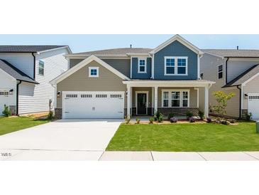 Charming two-story home with a two-car garage, well-manicured lawn, and inviting front porch at 1140 Sun Springs Rd, Wake Forest, NC 27587