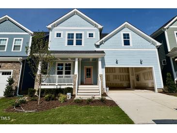 Charming two-story home with light blue siding, front porch, a two-car garage and landscaped front yard at 1237 Porters Call Dr, Wendell, NC 27591