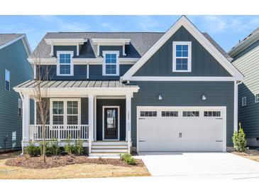 Charming two-story home with a well-manicured lawn and inviting front porch and a two car garage at 1237 Porters Call Dr, Wendell, NC 27591
