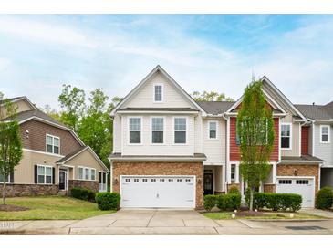 Charming two-story townhome featuring a stone-accented garage and manicured front lawn at 184 Wildfell Trl, Cary, NC 27513