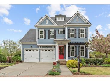 Charming two-story home boasts a red door, three-car garage, and professionally landscaped front yard at 200 Windy Knoll Cir, Chapel Hill, NC 27516