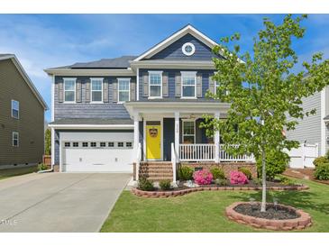 Charming two-story home with a welcoming porch, brick accents, and well-manicured lawn at 2308 Swansea Ln, Apex, NC 27502
