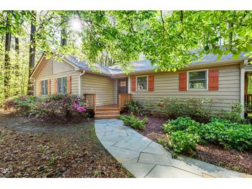 Charming one-story home with a stone walkway and colorful landscaping around the front of the house at 3217 Brennan Dr, Raleigh, NC 27613