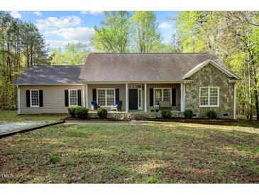 Charming single-story home featuring a stone facade, covered porch, and well-maintained landscaping at 359 Punch Hill Farm Rd, Rougemont, NC 27572
