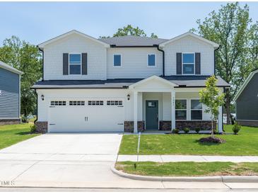 Charming two-story home with a two-car garage, manicured lawn, and inviting front entrance at 3841 Rosebush Dr, Zebulon, NC 27597