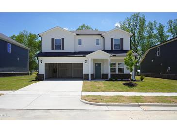 Inviting two-story home with a spacious driveway and a two car garage on a manicured front lawn at 3841 Rosebush Dr, Zebulon, NC 27597