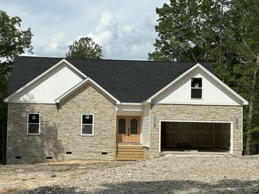 Stone and siding new construction home featuring a black roof and an attached two car garage at 42 Ponchartrain St, Fuquay Varina, NC 27526