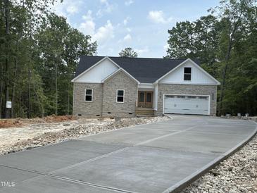 New construction features stone and vinyl siding, a two-car garage and a concrete driveway at 42 Ponchartrain St, Fuquay Varina, NC 27526