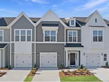 Charming townhomes with gray and white siding, attached garages, and well-maintained landscaping at 43 Pansy Park # 233, Clayton, NC 27520