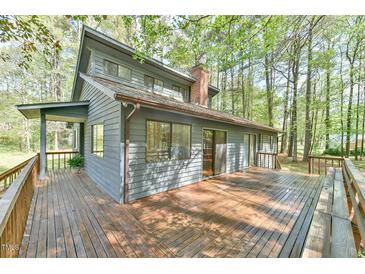 A charming home with a large wooden deck, perfect for entertaining, surrounded by mature trees at 505 Marion Way, Chapel Hill, NC 27516