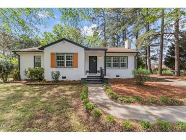 Charming white brick home with black trim, shutters, and a landscaped front yard at 711 Horton Rd, Durham, NC 27704