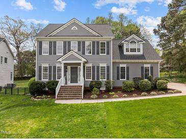Charming gray home with manicured landscaping, brick steps and black shutters at 104 Dallavia Ct, Morrisville, NC 27560
