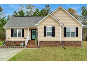 Charming single-story home with light yellow siding, black shutters, and well-manicured lawn at 114 Carriage Hill Dr, Stem, NC 27581