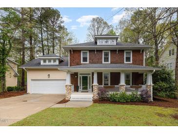 Charming two-story home with a welcoming front porch and well-maintained lawn surrounded by mature trees at 120 Cypress View Way, Apex, NC 27502