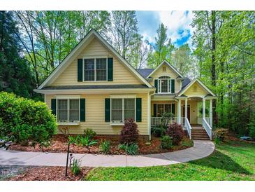 Charming home featuring a manicured front lawn, stone walkway, and inviting front porch perfect for a Gathering at 18 Green Ridge Ln, Pittsboro, NC 27312