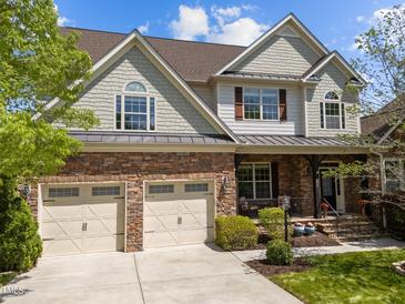 Charming home with a two-car garage, stone accents, and a welcoming front porch at 224 Clear River Pl, Cary, NC 27519