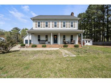 Traditional two-story home with a welcoming front porch and neatly maintained landscaping at 230 Bradley Dr, Benson, NC 27504