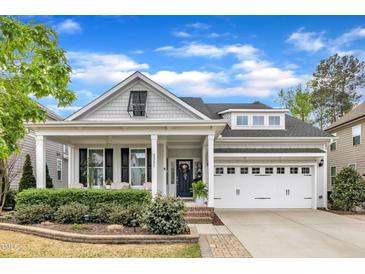 Charming home featuring a covered porch with white columns and manicured landscaping at 2321 Swansea Ln, Apex, NC 27502