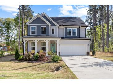 Charming two-story home featuring a covered front porch, two-car garage and manicured lawn at 254 W Odell Ln, Zebulon, NC 27597