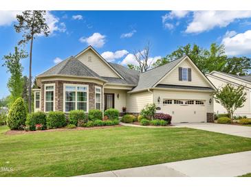 Charming home features a manicured lawn, beautiful landscaping, and an attached two-car garage at 2613 Beckwith Rd, Apex, NC 27523