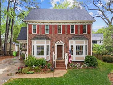 Charming two-story brick home with red shutters, bay windows, and a well-manicured front yard at 2613 Hiking Trl, Raleigh, NC 27615
