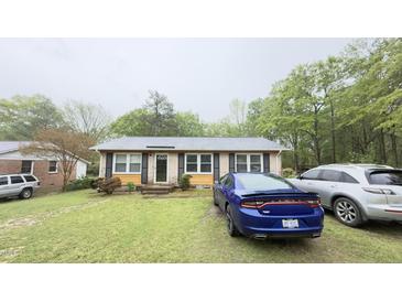 Charming single-story home with a well-maintained front lawn and multiple cars parked in front at 300 E Vance St, Zebulon, NC 27597