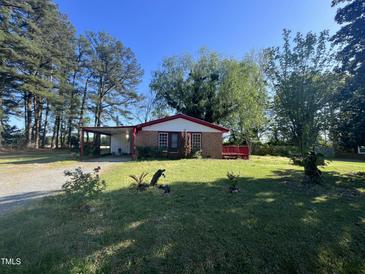 Charming single-story home with lush front yard and mature trees providing shade at 327 Holland Dr Rd, Smithfield, NC 27577