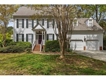Charming two-story home with white siding, dark shutters, and a well-maintained front yard at 3308 Churchill Rd, Raleigh, NC 27607